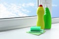 Cleaning supplies and sponges on window sill indoors, space for text