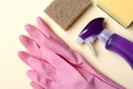 Cleaning supplies on yellow background. Top view detergent spray bottle, sponge, rubber gloves. Bathroom cleaning service Royalty Free Stock Photo