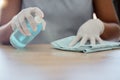 Cleaning, table and woman with spray bottle, cloth and dusting furniture in home. Closeup hands of cleaner, housekeeper