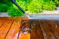 cleaning terrace with a power washer - high water pressure cleaner on wooden terrace surface Royalty Free Stock Photo