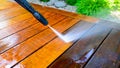 cleaning terrace with a power washer - high water pressure cleaner on wooden terrace surface Royalty Free Stock Photo