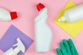 Cleaning tools company concept. White bottles with detergents and cleaning products and a sponge on a rose background Royalty Free Stock Photo