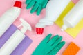 Cleaning tools company concept. White bottles with detergents and cleaning products and a sponge on a rose background Royalty Free Stock Photo