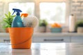 Cleaning tools in an orange bucket on a modern kitchen countertop with sunlight cleaning concept Royalty Free Stock Photo