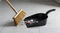 Cleaning Up the Mess: Broom and Dustpan on Tiled Floor Royalty Free Stock Photo
