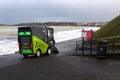 Cleaning vehicle cleaning the promenade at Ballyholme, Bangor Ireland during a gale in spite of the breaking waves