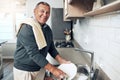 Cleaning, washing dishes or portrait of happy old man with soap water in kitchen sink in healthy home. Dirty, smile or Royalty Free Stock Photo