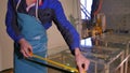 Worker clean and dry the glass on manufacture. Smiling mid adult worker cleaning soap sud on glass window with squeegee Royalty Free Stock Photo