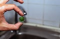 Cleaning the water tap. The male hand holds a clogged aerator. Sediment in water