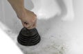 Cleaning a white ceramic sink with a black plunger. Closeup Royalty Free Stock Photo