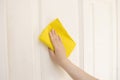 Cleaning a white door with a yellow cloth