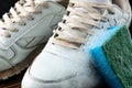 Cleaning of white sneakers on dark wooden background. Brush and solution of water and detergent Royalty Free Stock Photo