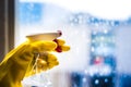 Cleaning window with squeegee with blue sky . Hand in yellow glove. Royalty Free Stock Photo