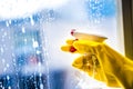 Cleaning window with squeegee with blue sky . Hand in yellow glove. Royalty Free Stock Photo