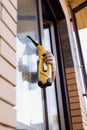 Cleaning window using portable vacuum windows cleaner. Washer of cleaning service cleans outside of the window to remove