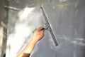 A young man cleans and polishes windows with a sponge