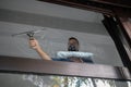 A young man with cleans and polishes windows with a sponge Royalty Free Stock Photo