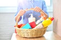 Cleaning woker from service holds a basket with household chemicals