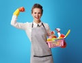 Cleaning woman with a basket with cleansers and brushes showing