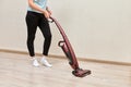 Cleaning lady cleans dust with cordless handheld vacuum