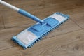 Cleaning wooden floor with blue wet mop. Royalty Free Stock Photo