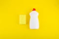 Cleaning yellow sponge and detergent for dishes on a yellow background. Top view, flatlay, close up. Concept cleaning company,