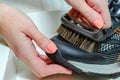 cleans sports shoes, woman cleans shoes with a brush. Sneakers after running. Royalty Free Stock Photo