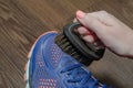 cleans sports shoes, woman cleans shoes with a brush. Sneakers after running. Royalty Free Stock Photo