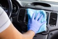 Cleansing car interior. Male hand in protective glove disinfecting vihicle inside