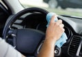 Cleansing car interior and wheel. Male hand  disinfecting vihicle inside Royalty Free Stock Photo