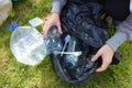 Protecting the world from plastic. A woman collects garbage from the grass. Royalty Free Stock Photo