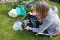 Protecting the world from plastic. A woman collects garbage from the grass. Royalty Free Stock Photo