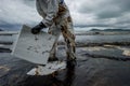 Cleanup crews fill bags with oiled sand and debris after a pipeline spilling oil into an Royalty Free Stock Photo