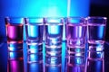 clear alcohol samples in glass beakers exposed to uv light