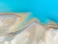 Clear azure water in a mountain lake. The shore with stones. View of the water from a drone.