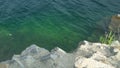 Clear azure water, rocky shore with large granite stones Royalty Free Stock Photo