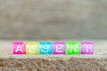 Clear bead with letter in word absent on wood background