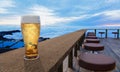 Clear beer glass with full cold beer and foam at the mouth of the glass And water droplets adhere to the edges. Plank or wood