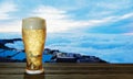 Clear beer glass with full cold beer and foam at the mouth of the glass And water droplets adhere to the edges. Plank or wood