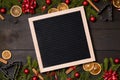 Clear black felt letter board flatlay on dark rustic wood table with Christmas decoration and fir tree boarder. Top view with