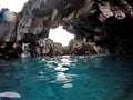 Clear blue ocean water in a lava rock cavern