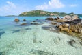 Clear blue sea water with stone and big mountain. Royalty Free Stock Photo