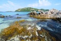 Clear blue sea water with stone and big mountain. Royalty Free Stock Photo