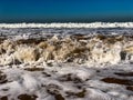 Clear blue skies and sunlight with Atlantic Ocean waves crashing onto sand beach with no people in Agadir, Morocco, Africa Royalty Free Stock Photo