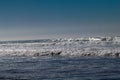 Clear blue skies and sunlight with Atlantic Ocean waves crashing onto sand beach with no people in Agadir, Morocco, Africa Royalty Free Stock Photo