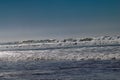 Clear blue skies and sunlight with Atlantic Ocean waves crashing onto sand beach with no people in Agadir, Morocco, Africa Royalty Free Stock Photo