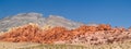 Clear blue sky above red the striped rock outcrops and hilss of