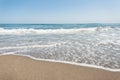 Clear blue sky above the surface of a hectic sea with waves and white foam. Ocean water view from the sea coast. Summer.