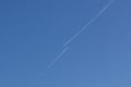 Clear blue sky with condensation trail of plane Royalty Free Stock Photo