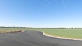 Clear blue sky and distant farmland newly paved road